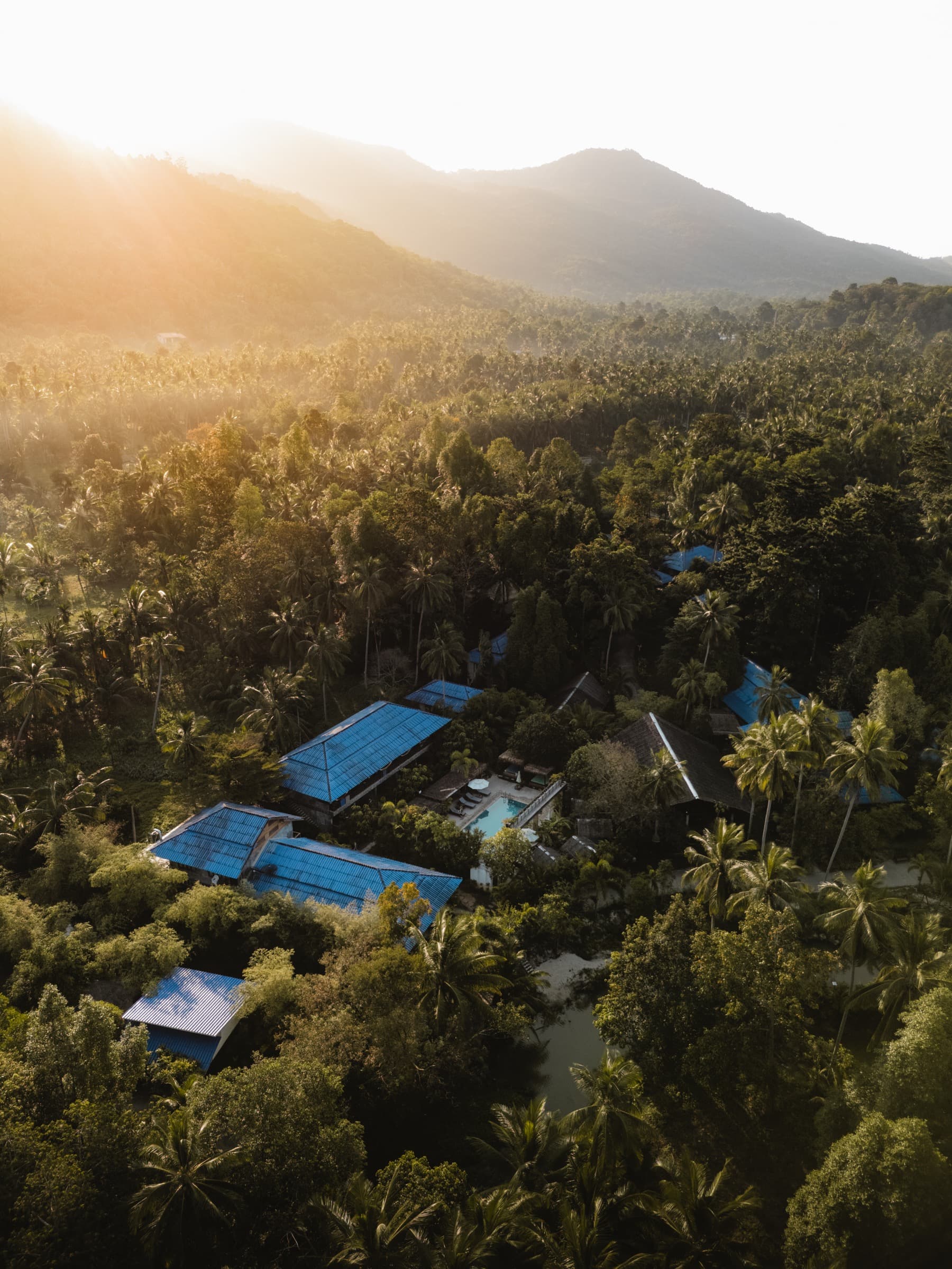 Aerial view of Wonderland Healing Center with blue roofs and mountain backdrop